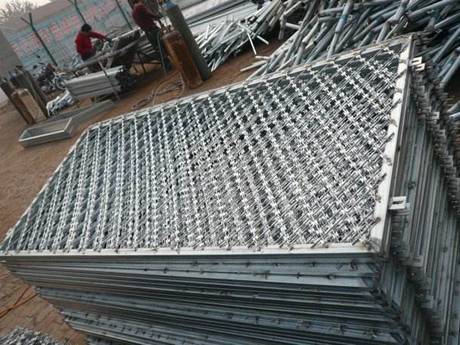 A bundle of galvanized welded razor wire mesh on the ground.