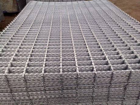A bundle of welded razor wire panels on the ground.